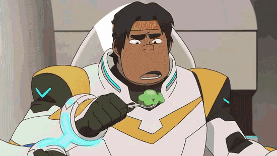 a man in a space suit is holding a spoon in his mouth