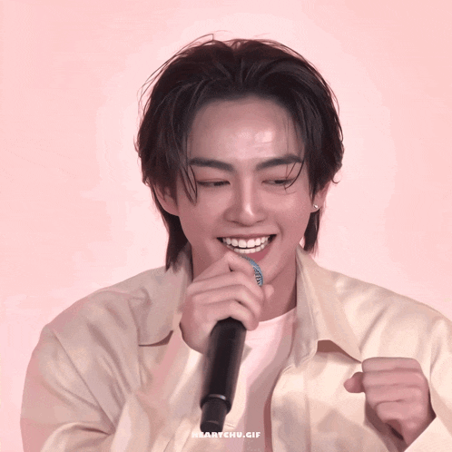 a close up of a person holding a microphone with the words heartchu.gif on the bottom right