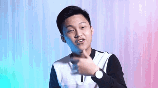 a young man wearing a watch is making a gesture