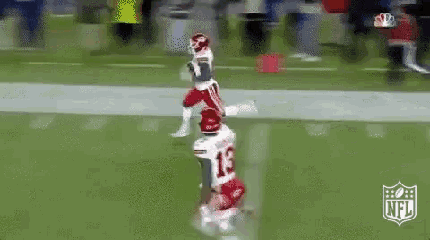 a football player wearing the number 13 is running on the field .