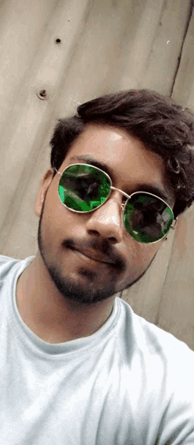 a man wearing sunglasses and a white shirt takes a selfie