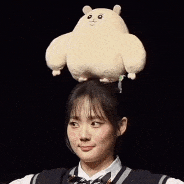 a girl has a stuffed animal on her head