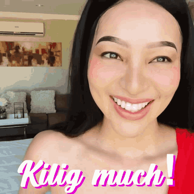 a woman is smiling in front of a sign that says ' kig much '