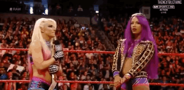 a woman with purple hair is talking into a microphone in a wrestling ring