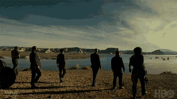 a group of people standing on a beach with a hbo logo in the corner