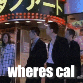 a group of people standing in front of a sign that says " wheres cal "