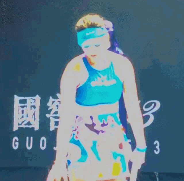 a woman is holding a tennis racquet in front of a sign that says gup573