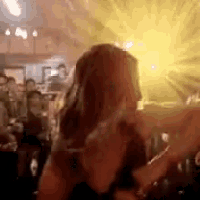 a woman is standing in front of a crowd of people at a concert .