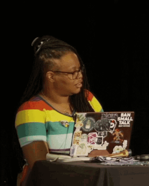 a woman is sitting at a table with a laptop that says dious ban small talk