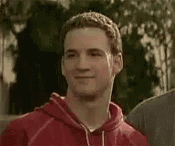 a man in a red hoodie is making a funny face while standing next to another man .