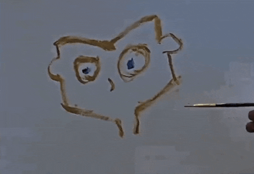 a person is drawing a face with a brush on a white board