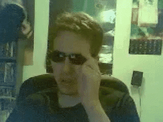 a man wearing sunglasses is talking on a phone