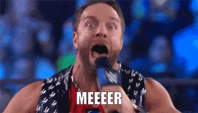 a wrestler is holding a microphone with his mouth open and the word meeeeer written on it .