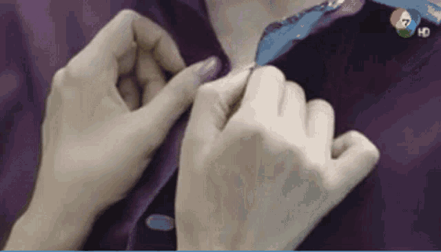 a close up of a person 's hands on a purple shirt with the number 7 on it