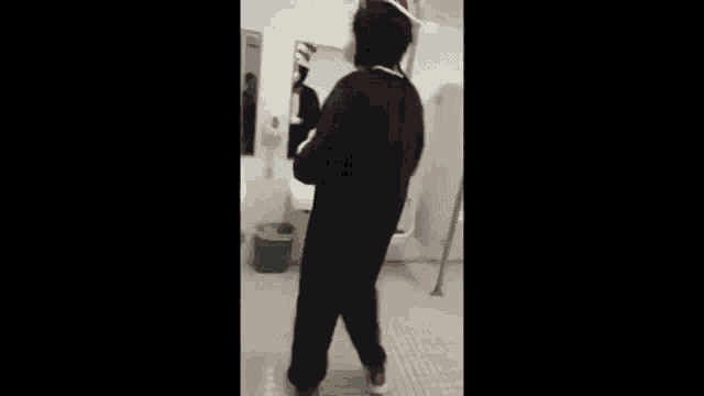 a person in a cat in the hat costume is standing in a bathroom next to a sink .