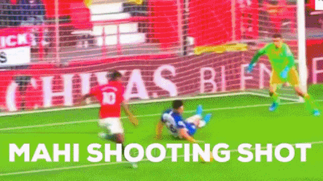 a soccer player is laying on the ground while another player tries to get a shot on the goal .