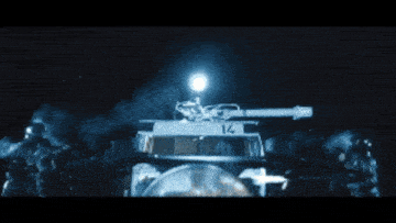 a man in a black suit is holding a gun in a dark room