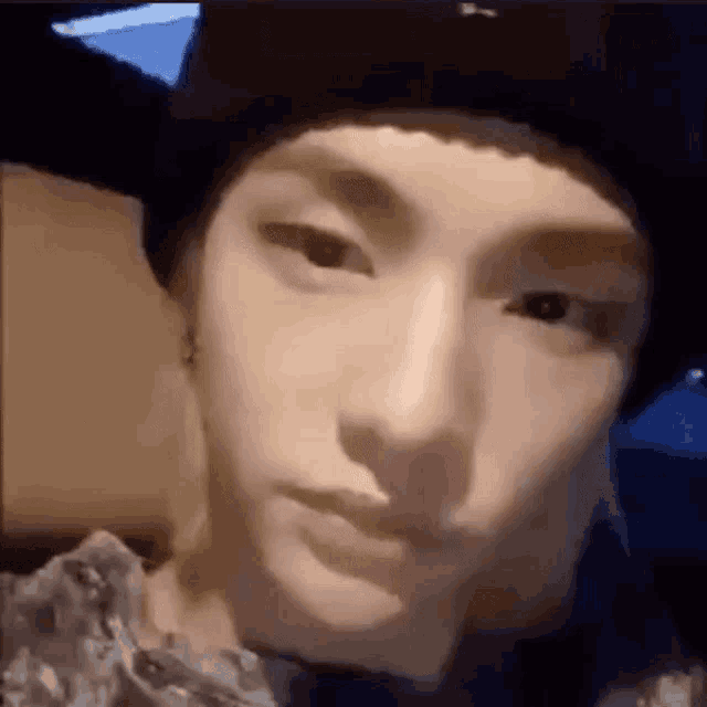 a close up of a person 's face wearing a hat and looking at the camera .