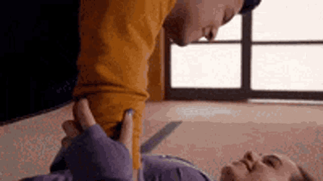 a man and a woman are laying on the floor . the man is touching the woman 's arm .