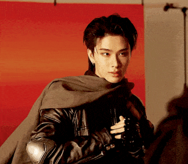 a man wearing a black leather jacket and a cape