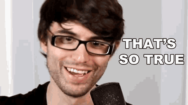 a man wearing glasses is smiling in front of a microphone and the words `` that 's so true '' are above him .