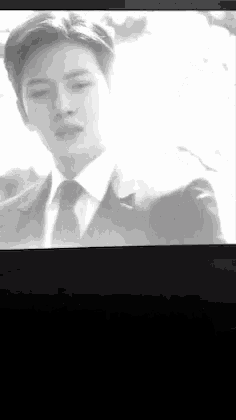 a black and white photo of a man in a suit and tie on a tv screen .