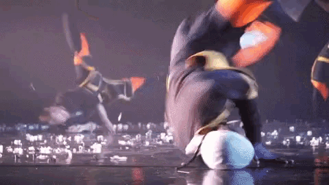 a person is doing a handstand on a stage in front of a crowd