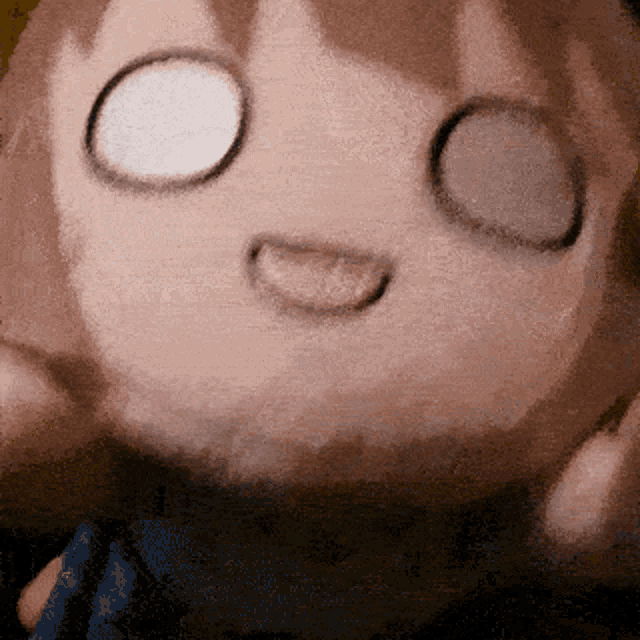 a close up of a stuffed animal with its eyes closed and its tongue sticking out
