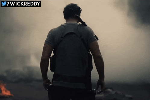 a man is standing in front of a fire with a twickreddy logo on the bottom