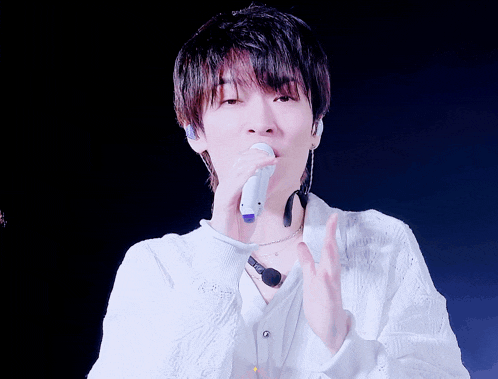 a man singing into a microphone while wearing headphones
