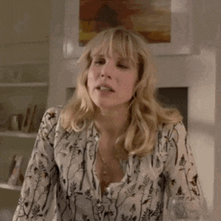 a woman with blonde hair is wearing a white shirt with a floral print