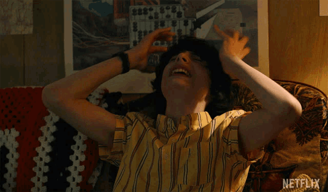 a man is sitting on a couch with his arms outstretched and a netflix logo in the corner