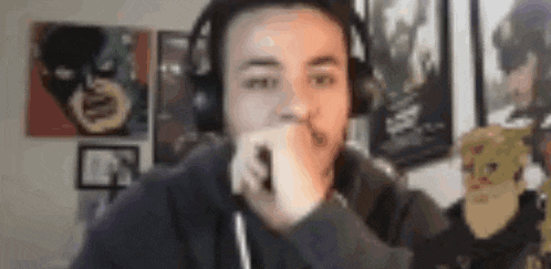 a man wearing headphones is sitting in front of a computer screen in a room .