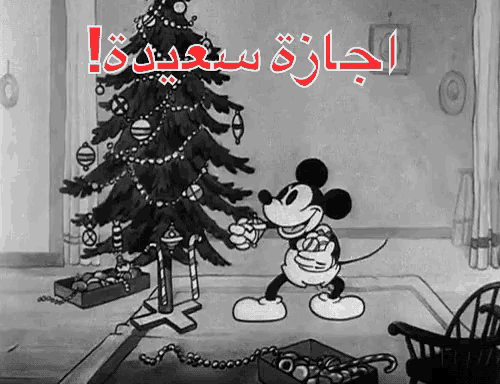 a cartoon of mickey mouse decorating a christmas tree with arabic writing