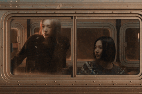 a group of people are riding on a bus and one of them is holding her finger to her lips