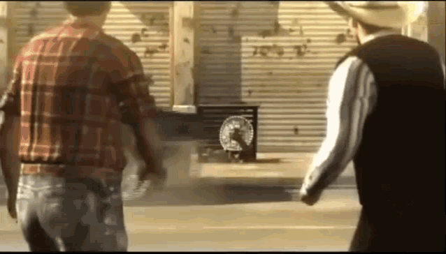 two men in cowboy hats are standing next to each other on a street