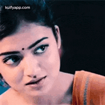 a close up of a woman 's face with a serious look on her face and a bindi on her forehead .