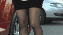 a close up of a woman 's legs in front of a car
