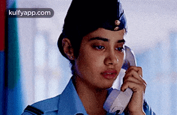 a woman in a police uniform is talking on a cell phone .