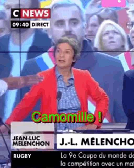a woman in a red jacket is giving a speech on a television screen