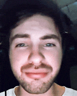 a close up of a man 's face with a beard wearing headphones