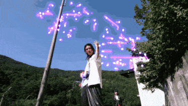 a man in a white shirt is standing in front of a purple explosion