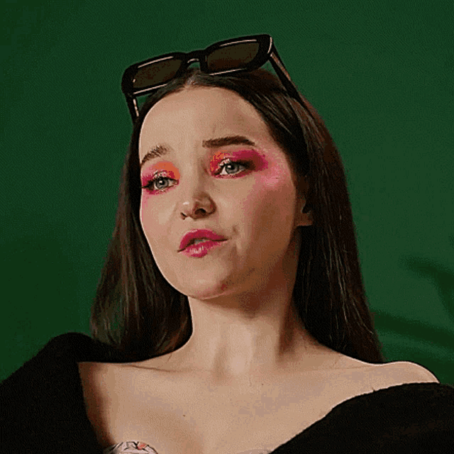 a close up of a woman wearing sunglasses and pink eyeshadow