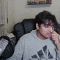 a man wearing an adidas sweatshirt is sitting in a chair