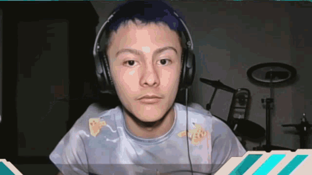 a man wearing headphones and a tie dye shirt looks at the camera