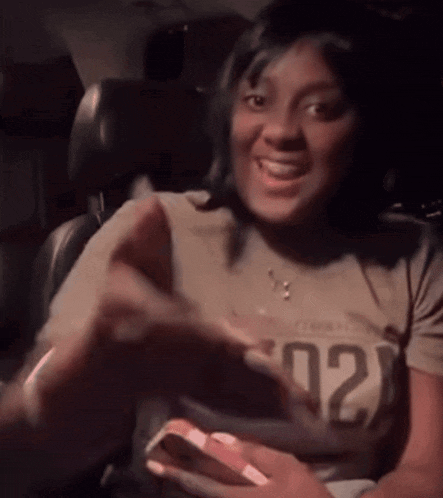 a woman in a car wearing a shirt that says 02
