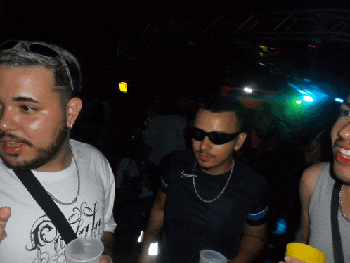 a man wearing sunglasses and a white shirt that says ' party ' on it