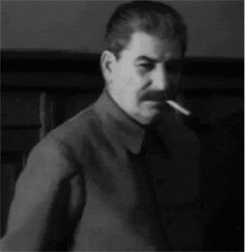 a man with a mustache is smoking a cigarette .