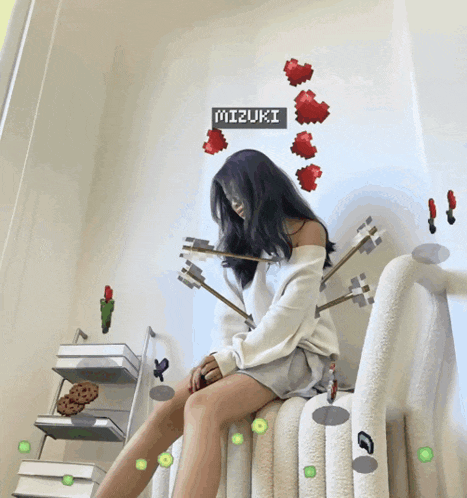 a girl is sitting on a bed with arrows coming out of her face and the name mizuki on the wall