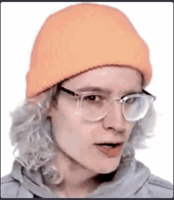 a man wearing glasses and an orange hat is making a funny face .